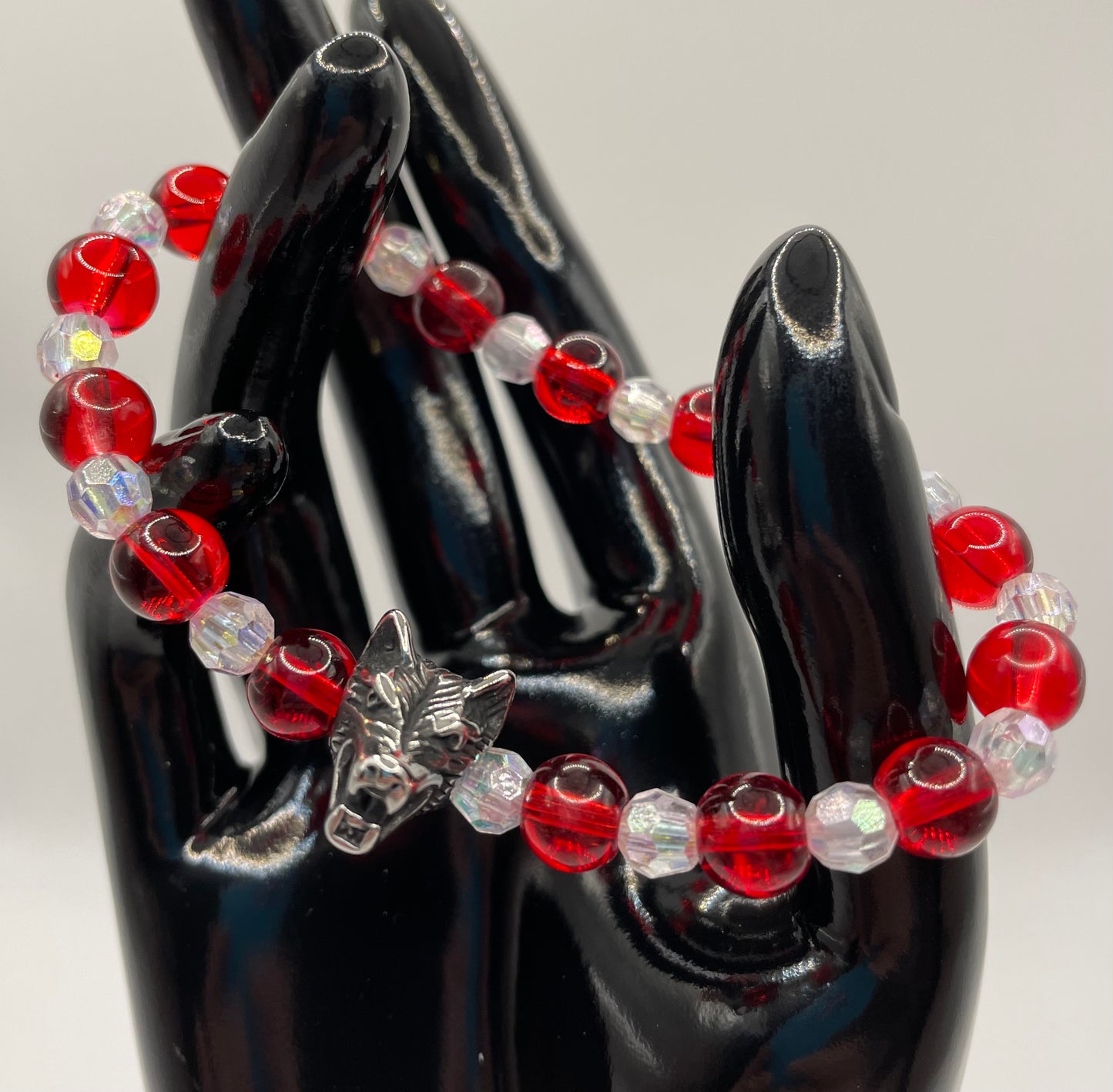 8mm red glass bead with 6mm faceted clear beads, plus a wolf head. Bracelet 6.75”