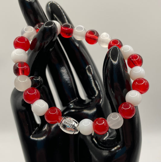 Red and white 8 mm glass bead stretch bracelet, with metal football accent charm. 6.5”