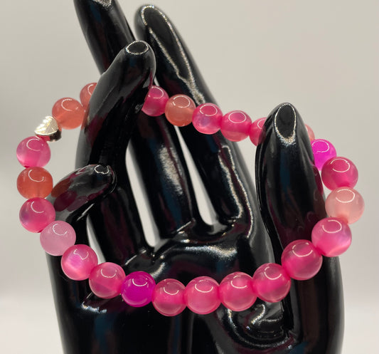 Shades of pink 8mm glass bead stretch bracelet with metal heart detail. 7”