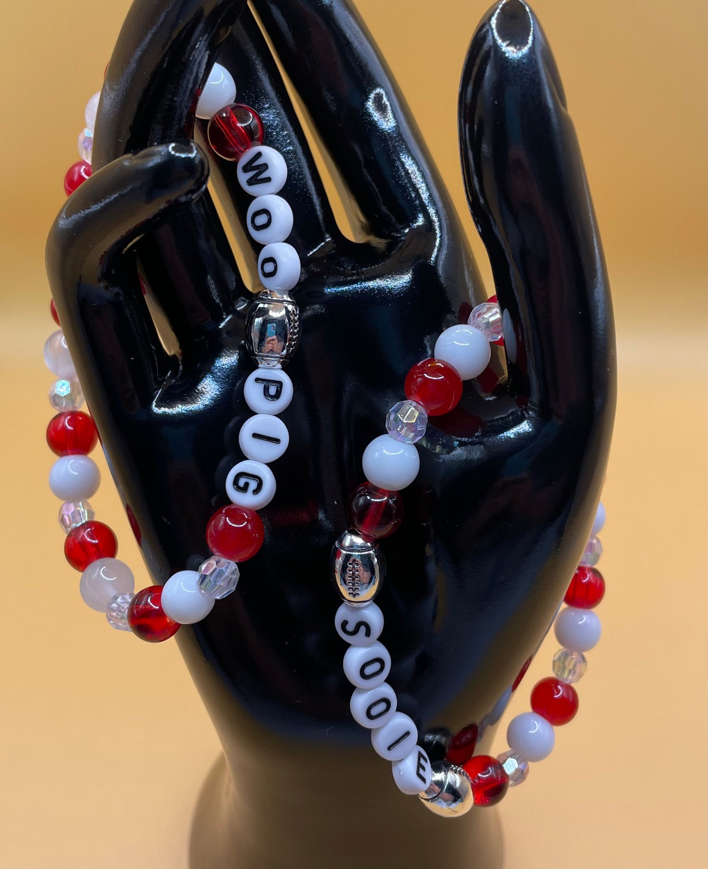 2 piece set of red & white bracelets. One says “WOO PIG” the other says “SOOIE”. 7”