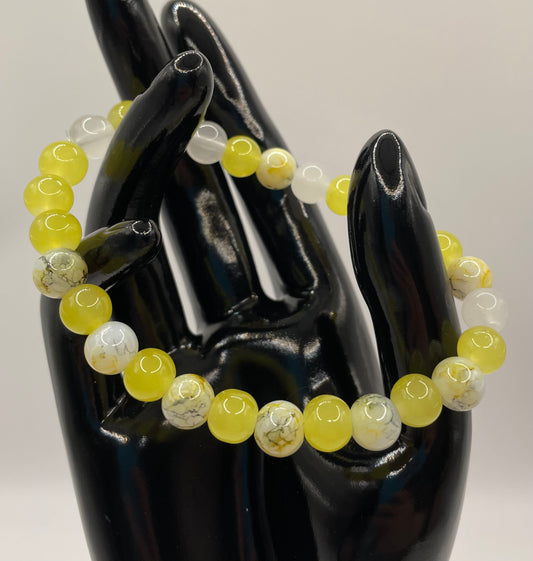 Multi colored yellow black and white 8mm glass bead stretch bracelet. 7.25”